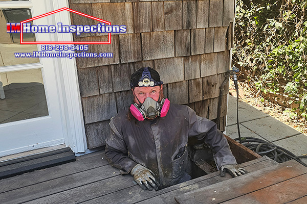 A home inspector coming out of a crawl space